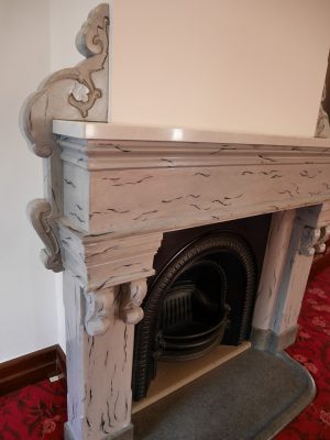 暖炉をじっくり眺めれば、天板以外の部分の大理石模様が漆喰塗りで再現されたものだと分かる