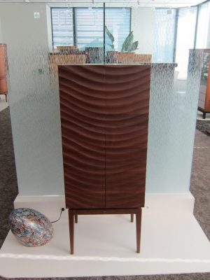 仏壇が一般に普及したのは江戸時代からといわれる。手を合わせ、故人を思うことはとても身近なことだった。八木研では、2000年に「現代仏壇」を販売する直営店をスタートさせてから、顧客の“生の声”を受け取ることができるように。そして、その声を商品開発にフィードバックすることで、都市型の仏壇をより現代に合ったものへと、より成長させることができたそうだ。写真はアメリカにある絶景スポットにちなんだ「アンテロープ」という商品名で、波や水の流れをイメージした彫刻が施されている。他の商品名には花の名前が付けられているものもあり、故人がその花を好きだったからと選ばれることもあるという</BR>（写真提供：ギャラリーメモリア 名古屋駅前店）