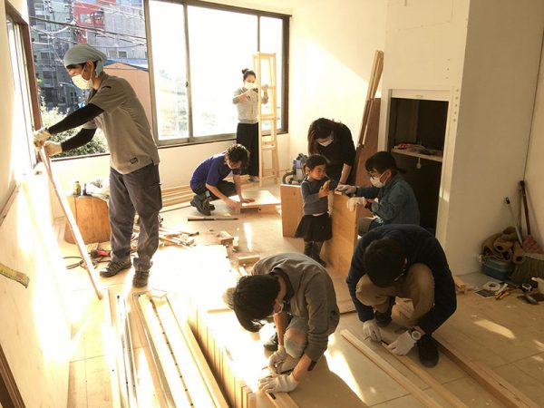 休日にDIYする並木さんご夫妻と応援する仲間や近隣の住民たち。小さな子どもも参加した