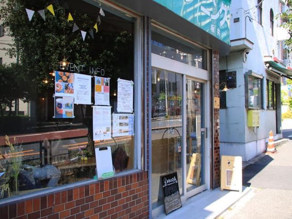 あえてかつてのクリーニング店の看板をそのまま残した外観。当時を知る人への目印になるからだ。ガラス窓に、イベント等のスケジュールを掲示するようにした