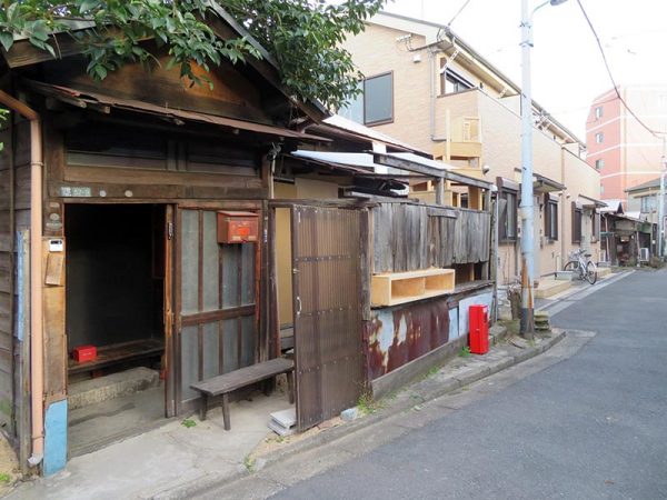 明治通りからほんの数メートル入ったところに立地。路地の奥には長屋が見えていた