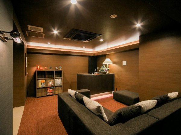 6階にある共用部となる受付ホール。シェアハウスなどの住人やオフィスの来客との打ち合わせやミーティングに利用できる。白い外観とは打って変わって、この受付や玄関ホールなどはブラウンベースのぐっと落ち着いた雰囲気となっている(写真提供：かがやき建物)