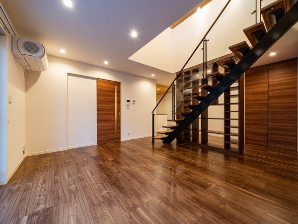 大型壁面書棚のある住まいの1階部分。この部屋も階段はスケルトンでその向こうに書棚がある