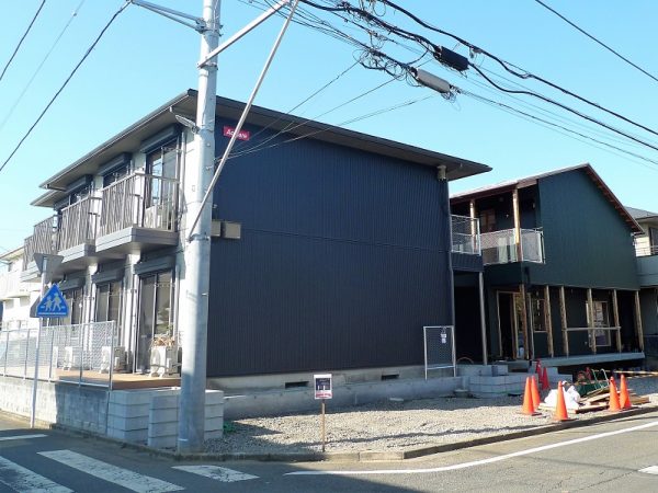 「ノビシロハウス亀井野」。手前が築17年のアパートをリノベした住居棟。奥の新築2階建ての建物にはカフェやランドリー、</BR>医療施設などが入居する