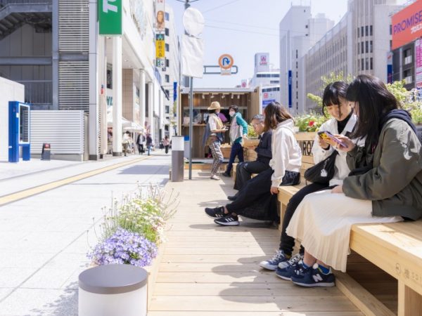 八丁堀バス停（東急ハンズ前）のバスベイをウッドデッキに変貌させた、広島初のパークレット。木製のベンチでスポンサー名をPR