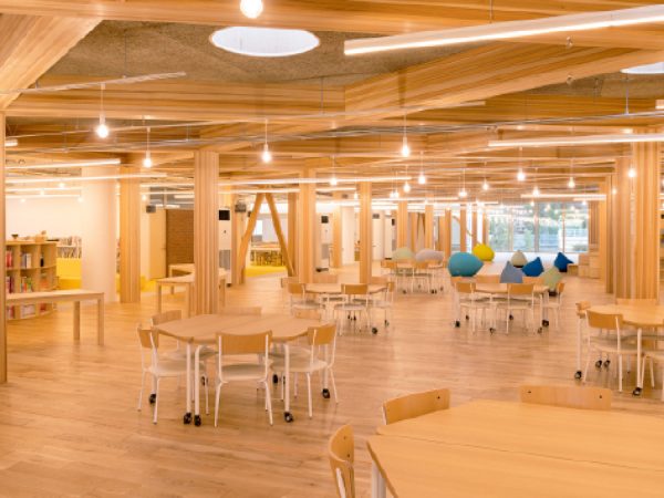 新築された「ラーニングコモンズ」は、隣り合う空間と混じり合うような、木のあたたかみ漂うオープンスペース。</br>配管むき出しのデザインでライブ感も演出した