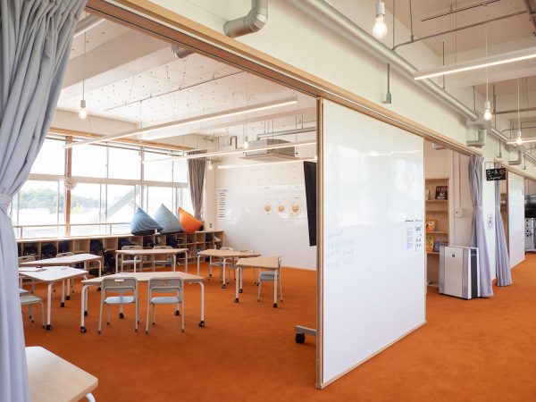 教室も廊下もオレンジ色のカーペット敷き。壁がないとはいえ、吸音ボードなどを用いて音にも配慮