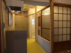 写真奥がトイレ、洗濯機置き場。その上部の棒材が洗濯物干しに使える