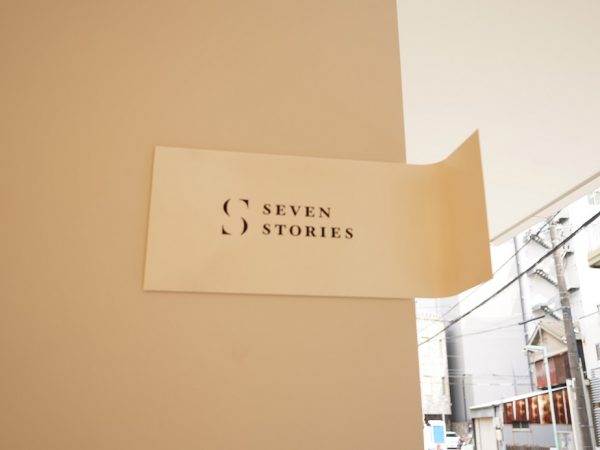 1階のエレベーター脇の案内表示。7つの物語というコンセプトから本の目次をイメージしたデザインで、1階は“始まり”とし、2～8階は各部屋のタイトルを記している。また、エントランスの扉には「はじめに」として、施設を紹介する文章が書かれている