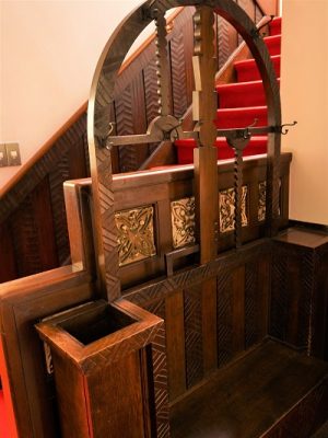 洋館の玄関に置かれたオリジナル家具。建物が建てられたときに合わせてオーダーされたもので、帽子かけやステッキ入れがあり、外国人のゲストが来たときに身支度をするのに使われた。上部の半円の真ん中に上下に延びる木は、鍵をモチーフにしたデザインが施されている