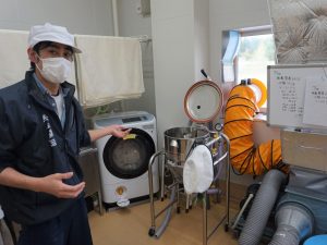 若手の杜氏さんに酒蔵を案内してもらった。後ろには洗米機がある