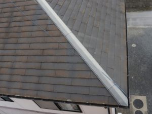 日本の一戸建てでよく見られる「スレート」と呼ばれる屋根材（写真）は、塗膜の剥がれやスレートの反りが原因で雨漏りしてしまうので塗装が必要。瓦の場合は、種類によって塗装か葺き替えかが異なる