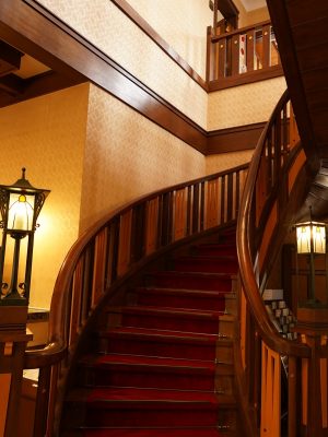 大広間の螺旋階段。エレガントな雰囲気で、2階のプライベートスペースから、芸妓、女優として人々を魅了してきた貞奴が降りてくる姿を想像してしまう。消防法の関係で創建時より幅が広められ、上部はほぼ直線に近い状態に変更された