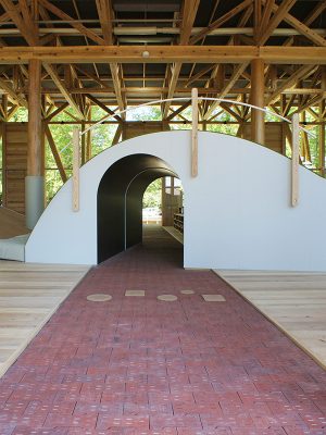 トンネルのような遊具には外から施設内を突き抜ける通路が。靴を脱いで利用する屋内と土足で過ごす屋外、有料部分と無料部分の境目が曖昧になっていることも面白い