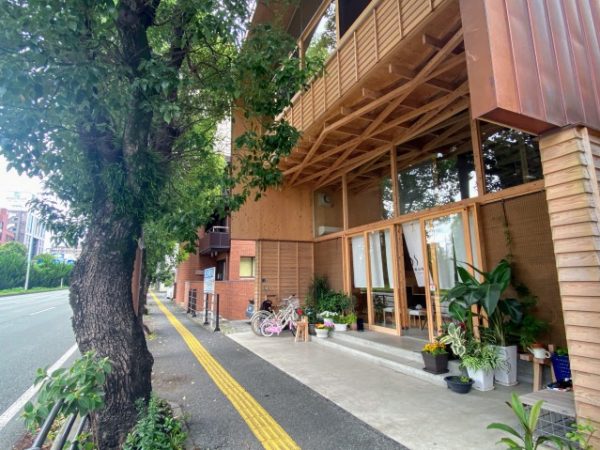 交通量の多いバイパスに面して立つ。入り口は歩道から少しセットバックし、湯上がりに涼めるベンチが設けられている