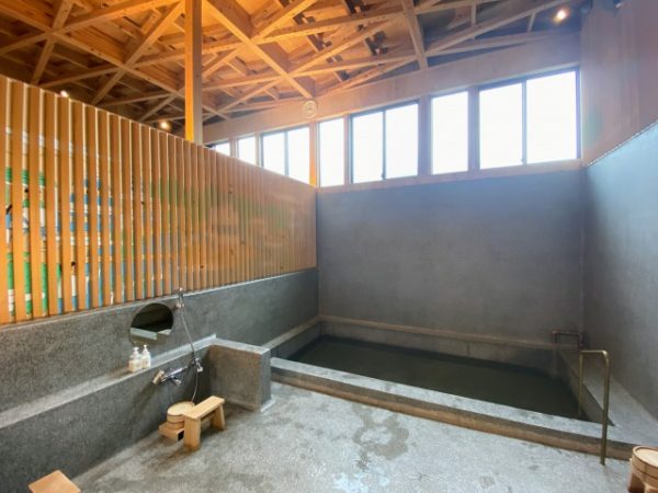 浴場の天井に見えるのが「重ね透かし梁」。洗い場の床と浴槽、壁の立ち上がりまで、現場施工のテラゾー（人造大理石）で一体に仕上げている。お湯は地下から水を汲み上げ、温室効果ガスを増やさない都市ガスで沸かす