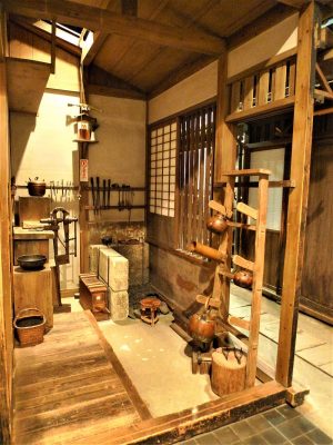 長屋住まいの一角で仕事をする居職の銅壷職人。作業場にはさまざまな道具があり、ひとつひとつの工程を手作業で行っていた。このように手間ひまかけてものをつくっていた時代、使い捨てにするという生活習慣はなく、傷んだ部分を修理しながら長く使っていた