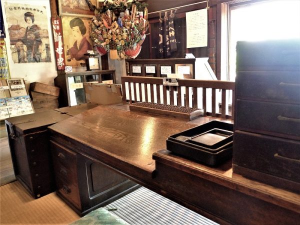 店の床は、間口いっぱいに土間になっている。そして中央奥に設けられているのが帳場。帳場には帳場格子と呼ばれる折りたたみのできる低い格子が、お客との境界として置かれている

