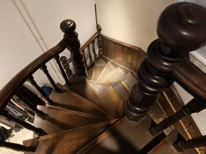 途中の踊り場から二股に分かれている階段。手すりや床、腰板もきちんと手入れされてきたことが分かる