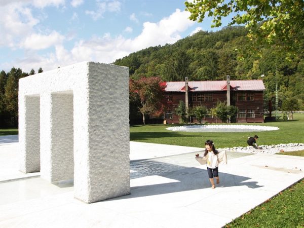 アルテピアッツァの魅力を教えてくれた影山さん。奥には、無心で石を彫る人たちの姿が