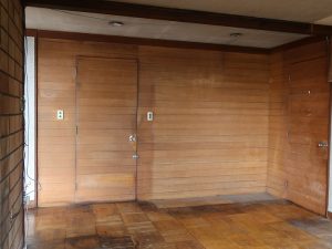 ダイニングから風呂などの水回り、勝手口に続くドア、壁。木がきれいにそろえて貼られていることに注目