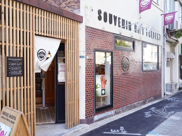 もともとあったタイルを残した外観が、まちの歴史を物語る。堀江さんの会社のデザイナーが考えたロゴは、家紋をモチーフにして、大松旅館という元の旅館の名前からとった松と、お土産の絵を入れている