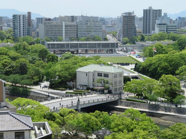 写真奥にある細長い建物が広島平和記念資料館、手前の洋館は、現在広島記念公園レストハウスとして使われている旧大正屋呉服店。被爆時の姿を留めた地下室が残っている