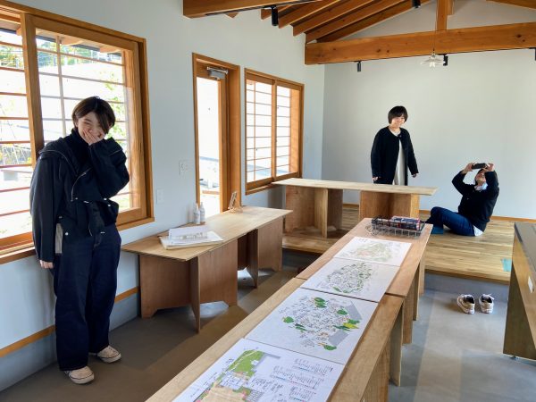 コミュニティハウスを見学する3人。プレゼン前日にデータが消えて焦ったことや、プロを相手に議論したことなど思い出を語り合う