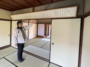 田辺与力直系子孫の苗秀社・今村結美さん。誓約状（複製）は、脱藩時に与力20名により署名と血判が押されたものだ。今村さんのご先祖様の名もある