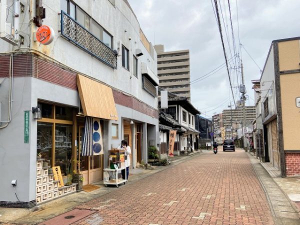 前原商店街西寄りの風景。雑貨のセレクトショップ「糸島ぐらし×ここのき」「暮らしの工藝舎」歴史ある商家を活用したレストラン「古材の森」、ブックカフェ「ノドカフェ」などが集まっている