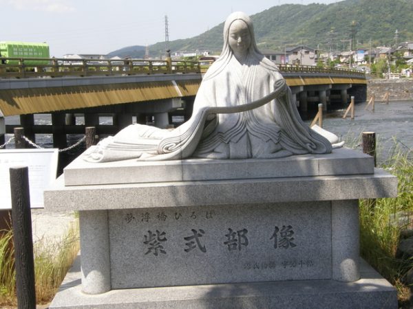 源氏物語の「若菜」や「初音」にも登場する「子の日の遊び」に食べられた若菜入りの汁物も七草粥風習につながるとされる（写真は京都市宇治市の紫式部像）