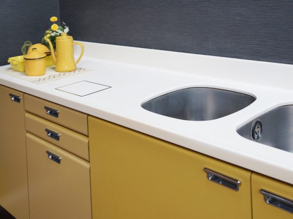 35年前のヤマハ製人造大理石キッチンカウンター。さすがに傷だらけだが、銀色のテープで囲んだ部分はキレイに磨かれていて新品同様によみがえっている。使うほどに愛着が湧き、カウンターを再利用してリフォームをする人もいる