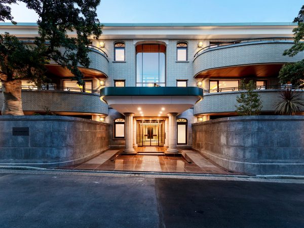 <ビフォー＞リノベーション前の正面エントランス外観。写真は1984年の竣工時の様子。やわらかなアールを描いたタイル張りの外装が印象的な高級賃貸住宅だった