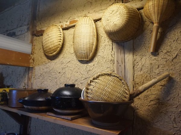 土壁にザルが並ぶ。山の資源は生活に欠かせないものが多かった