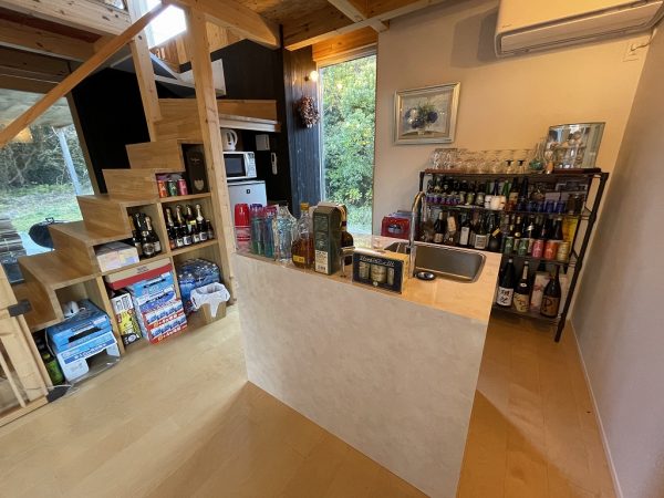 バーベキューができるメインホールと続く「応接スペース」には、個人宅とは思えないほどさまざまな種類のアルコールが揃う“バーカウンター”がある。ここで仲間と夜遅くまで語り合うこともあるそうだ。お酒が入ることで心の距離が近づくのかもしれない