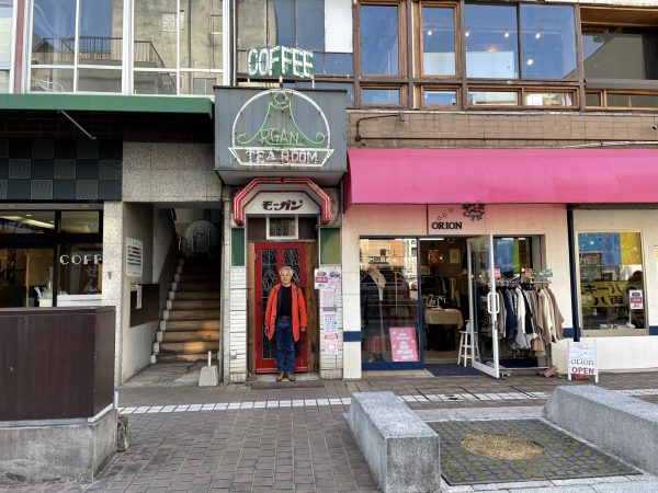 今回お話を伺った古山さん。彼が立っているのはメディアセンター事業をスタートした純喫茶モーガンの入り口。昭和の雰囲気漂う看板はそのまま残した