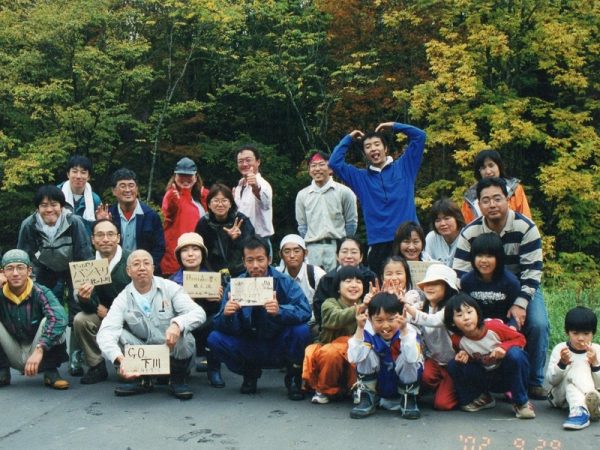 チェーンソーを手に丸太を切る富岡さん（右、富岡さん提供）
