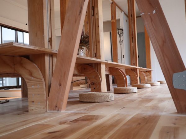 改修後の1階、コワーキングスペースの様子。棚やデスクはコンピュータ制御された木材加工機を活用して加工した。曲線にも対応する（写真／LIFULL）