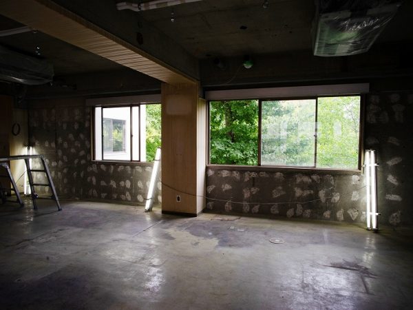 通りから見るとビル自体はごく普通のオフィスビル。右側に公園への入口がある