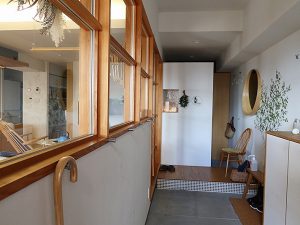 玄関を入ったところは細長い土間。リビングとの間には窓も。かっこいい