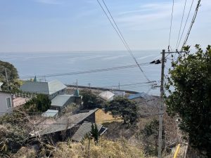 図書館に向かう急坂からは海が見渡せる。背後には緑豊かな丘陵地（写真：介川亜紀）