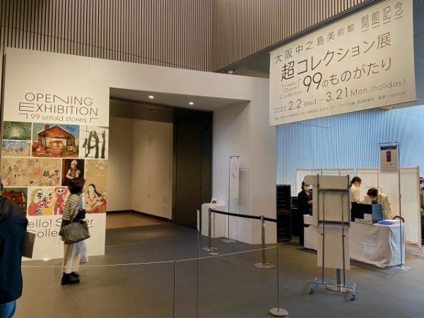 北側外観。道路面から1階分上がったところに芝生広場があり、そこからガラス張りの2階ホールにアクセスする。撮影時は「モディリアーニ ─愛と創作に捧げた35年─」（2022年4月9日〜7月18日）開催中で、これに合わせて広場でオープンカフェを営業していた。手前左のオブジェは大阪出身のアーティスト、ヤノベケンジが大阪中之島美術館のために制作した《SHIP’S CAT(Muse)》。この前で来館者が入れ替わり立ち替わり記念撮影していた