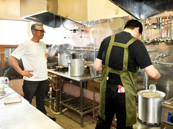 佐野らーめんの伝統技法「青竹打ち」の指導を受ける研修生