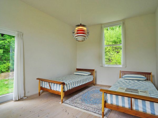 ▲グレートーンの白を多用しているフィン・ユール邸だが、キッチンだけは「真っ白」で統一されている。「家の中でキッチンがいちばん暗い場所にあるので、光を反射して明るくするために真っ白にしたようです。食器棚の扉もガラスになっていて、奥まで光が届く設計になっています」