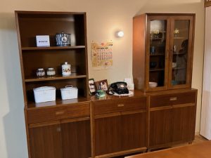 木製の食器棚。ダイヤル式の黒電話がとても懐かしい