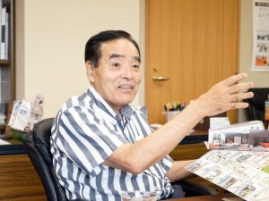 住宅について学べるすごろくを手にする石原社長。自身を、不器用で駆け引きができないと評する