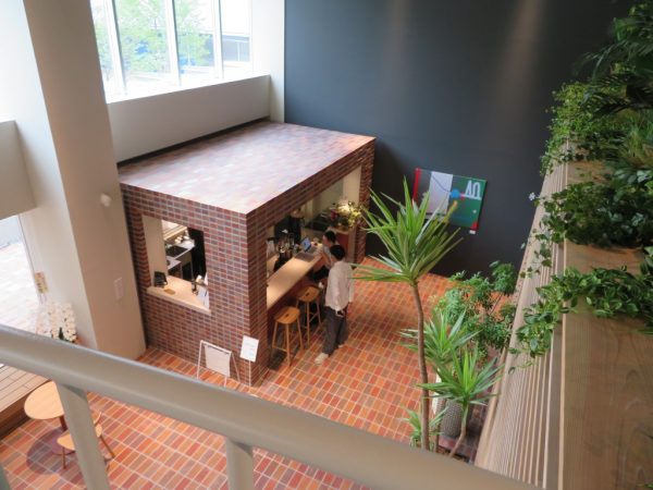 ロビーからの吹き抜けに面したつどにわライブラリー。カウンターデスクにはコンセントもあり、仕事にいそしめる。本棚の背後は1階営業室の吹き抜けだ