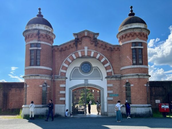 監獄の外から見た表門。双塔とアーチの上部を縁取る櫛形の装飾は、ロマネスク建築に見られる「ロンバルド帯」に倣ったもの。窓にはめられた鉄格子は建築当時そのままという