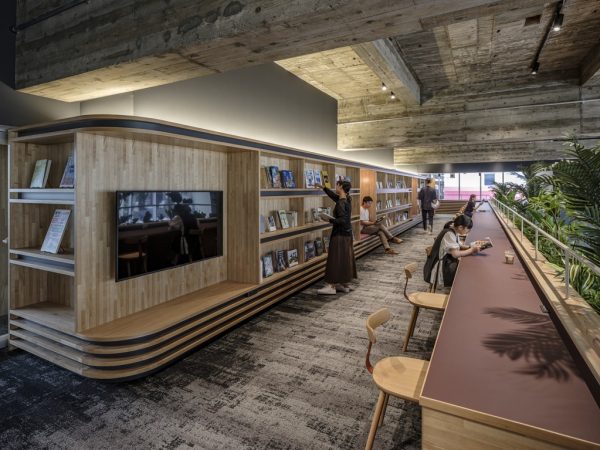 ロビーからの吹き抜けに面したつどにわライブラリー。カウンターデスクにはコンセントもあり、仕事にいそしめる。本棚の背後は1階営業室の吹き抜けだ