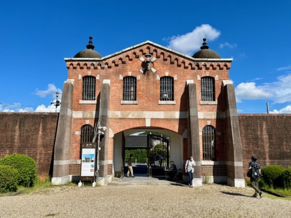 監獄の外から見た表門。双塔とアーチの上部を縁取る櫛形の装飾は、ロマネスク建築に見られる「ロンバルド帯」に倣ったもの。窓にはめられた鉄格子は建築当時そのままという